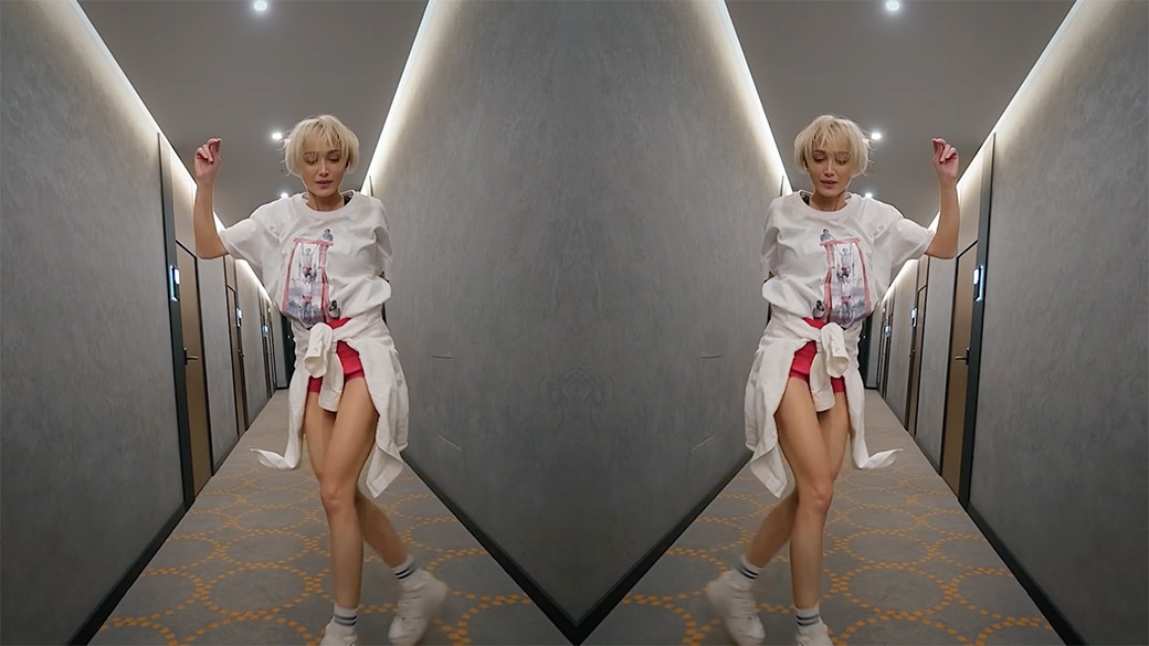 Mirrored image of girl dancing down a hallway